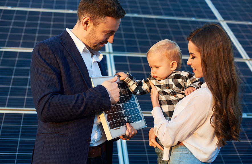 jeune couple avec leur enfant devant des panneaux solaires