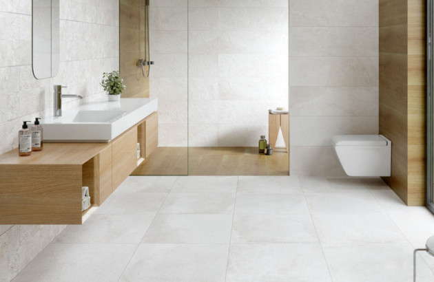 Salle de bains épurée avec WC suspendu blanc, meuble vasque en bois et douche à l’italienne.