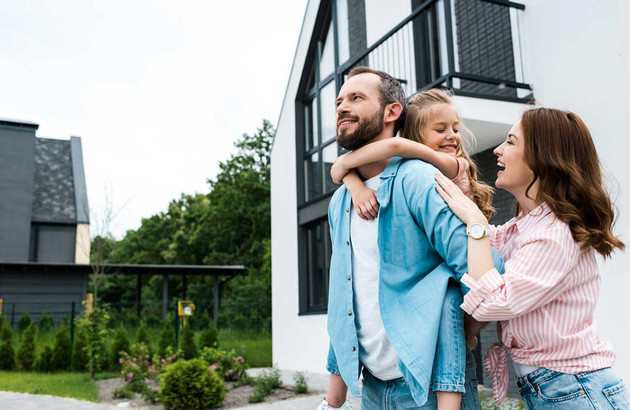 famille heureuse devant maison