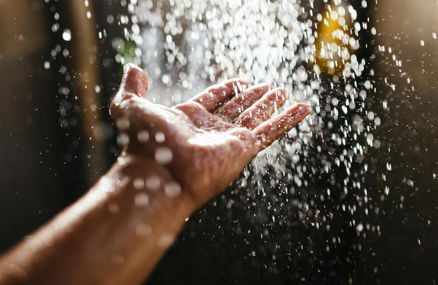 main sous l'eau chaude de la douche