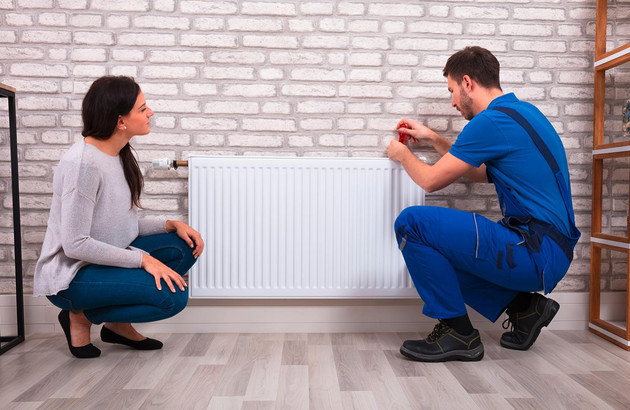 chauffagiste vérifiant le radiateur d'une cliente