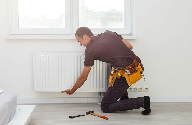 artisan en plein entretien d'un radiateur