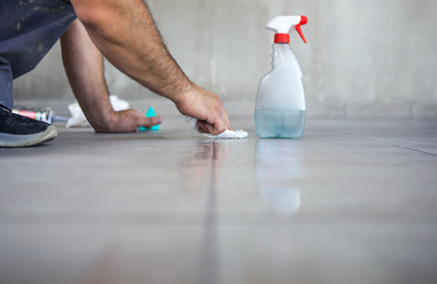 Personne essuyant du carrelage avec un torchon