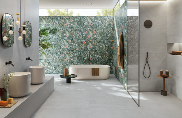 Carrelage gris effet beton au sol et dans la douche mélangé à un carrelage style papier peint ambiance jungle du côté de la baignoire (carrelage de la marque lafabbrica)