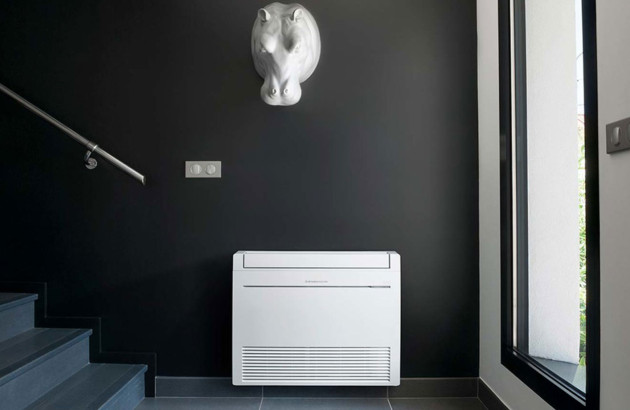 pompe à chaleur air-air sur un mur noir à côté d'un escalier sous une décoration d'hippopotame