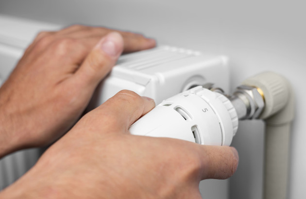 Homme qui utilise un thermostat de radiateur