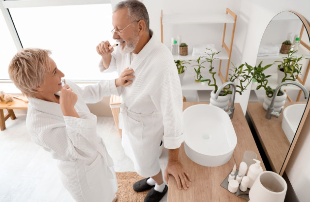 Couple en peignoir qui se brosse les dents une leur salle de bains lumineuse et esthétique
