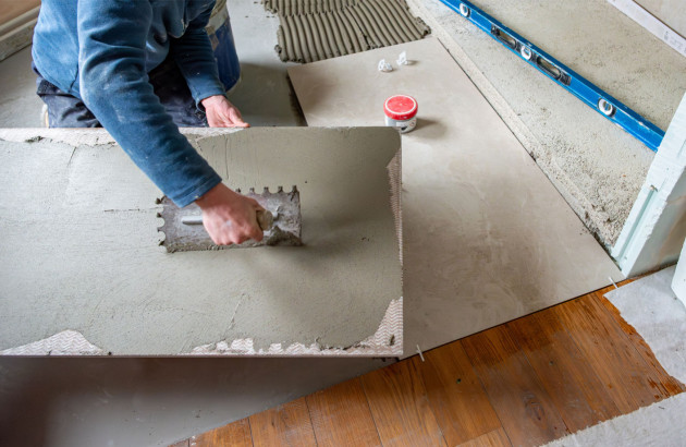 Homme qui installe des carreaux de carrelage XXL