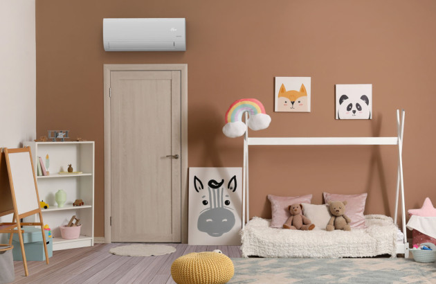 Chambre d’enfant avec climatisation monosplit installée au-dessus de la porte pour un meilleur confort thermique.