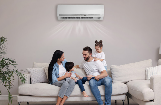 Famille installée dans un salon confortable sous une climatisation split diffusant de l’air frais.