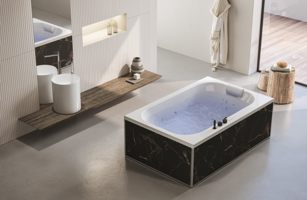 Baignoire balnéo avec habillage effet marbre noir dans une salle de bains design.