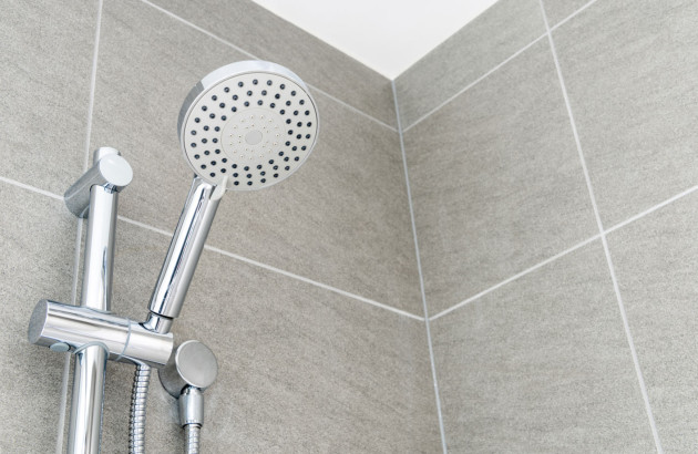 barre de douche avec un pommeau de douche, carrelage gris