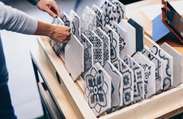 Homme qui pose ses mains sur une sélection de carrelage hexagonaux