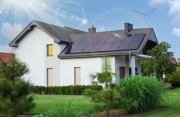 Maison moderne équipée de panneaux solaires intégrés à une grande partie de la toiture.