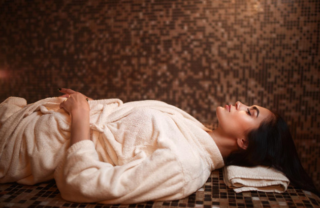 Femme allongée dans un hammam qui profite de ses bienfaits.
