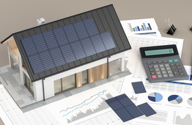 Simulation de production solaire avec calculateur et modèle de maison équipée de panneaux photovoltaïques.