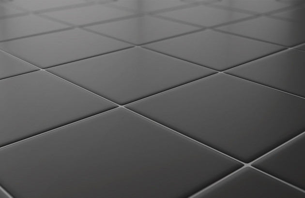 gros plan sur un carrelage antidérapant noir mat, adapté aux salles de bains accessibles et sécurisées