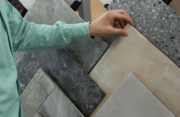 Homme qui touche différents carreaux de carrelage