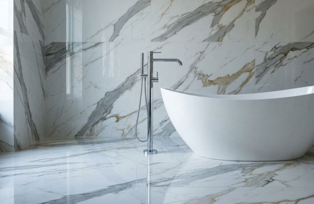 Salle de bains élégante avec grand carrelage imitation marbre blanc et baignoire design contemporaine.