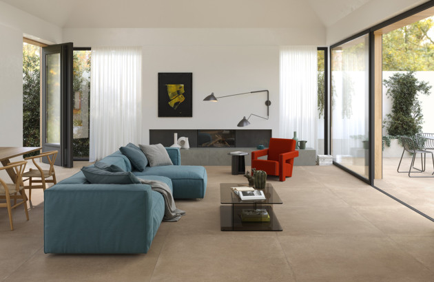 Salon contemporain avec grand carrelage sur mesure imitation pierre et larges baies vitrées lumineuses