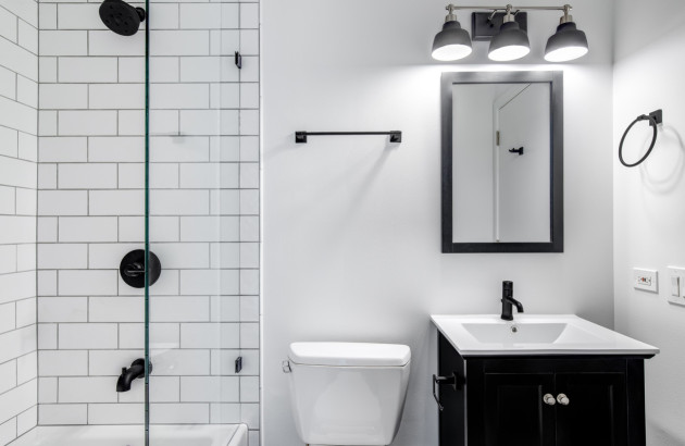 Petite salle de bains fonctionnelle avec douche, meuble vasque noir et rangements optimisés