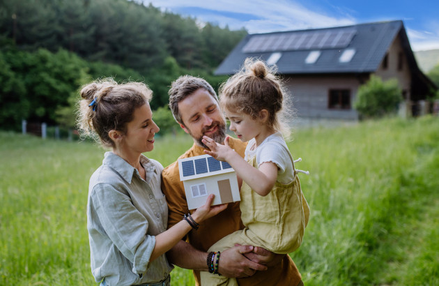 Famille devant une maison alimentée par l’énergie solaire