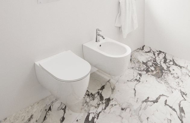 WC et bidet blancs assortis dans un espace minimaliste avec sol effet marbre.