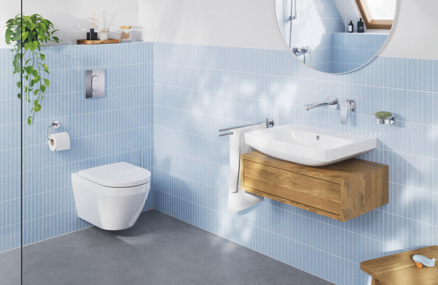Salle de bains lumineuse avec WC suspendu blanc, meuble vasque en bois et carrelage mural bleu clair.