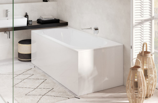 Baignoire rectangulaire encastrée contre un mur dans une salle de bains minimaliste.