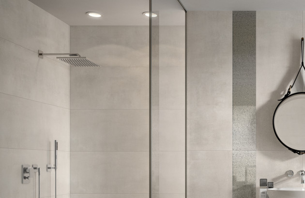 Douche moderne avec éclairage sécurisé et équipements électriques adaptés aux volumes réglementaires en salle de bains.