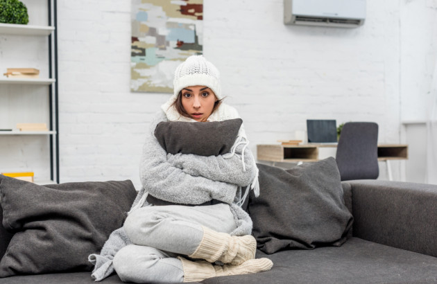 Personne souffrant du froid dans un salon avec climatisation