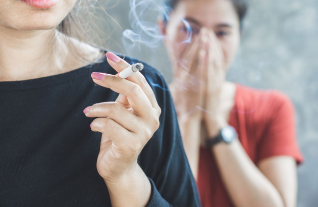 Femme incommodée par la fumée de cigarette