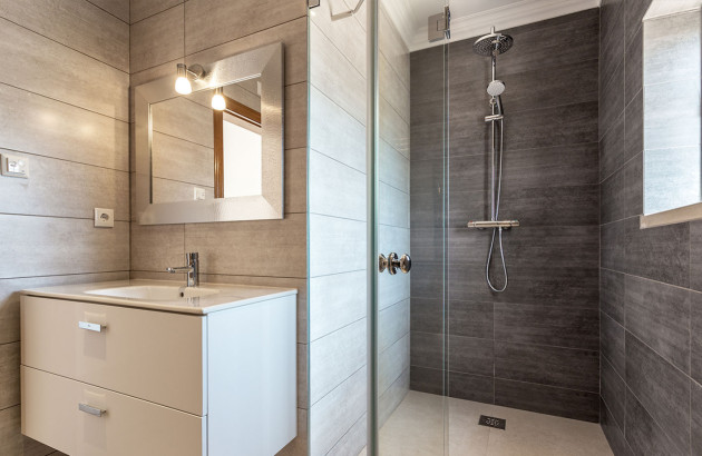 Douche à l'italienne avec une colonne de douche dans une salle de bains