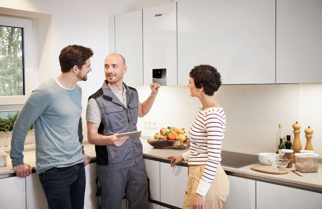 Technicien avec un couple effectuant le réglage de la chaudière Ecotec Plus Extracondens de chez Vaillant