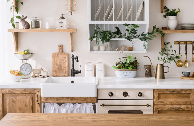 Cuisine rustique et lumineuse équipée d’un évier timbre d’office blanc, de meubles en bois massif et d’accessoires décoratifs.