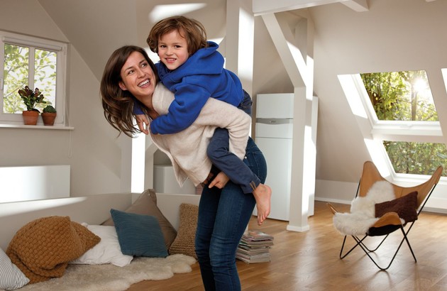 Mère et enfant heureux devant la chaudière gaz écoCompact Vaillant