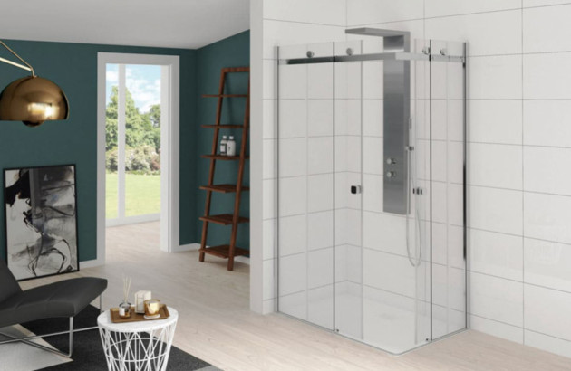 Douche d’angle avec parois vitrées coulissantes et profilés chromés.