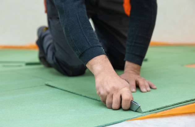 homme posant une plaque de sous-couche verte
