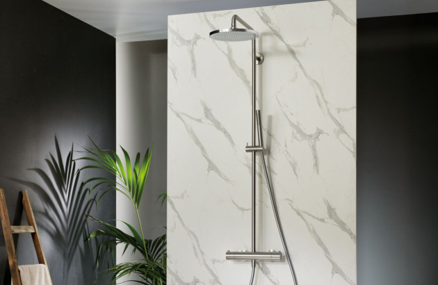 Colonne de douche en acier brossé installée sur un mur effet marbre dans une salle de bains design.