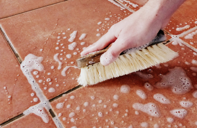 Nettoyage des joints de carrelage à la brosse avec une eau savonneuse