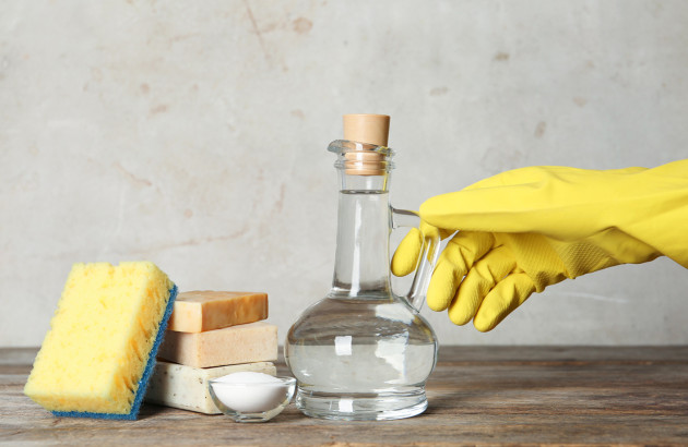 Personne avec des gants qui se prépare à utiliser des produits d'entretien