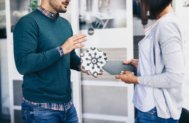 Homme qui conseille une femme sur le carrelage hexagonal