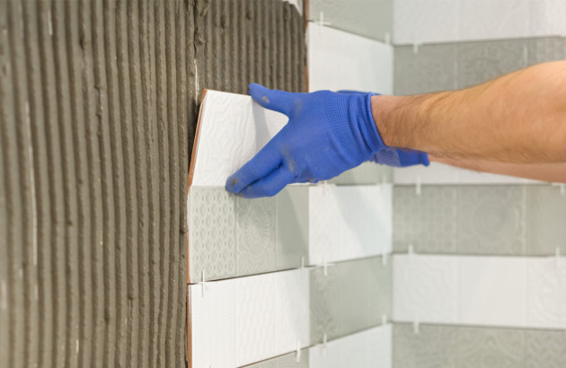 Pose de carrelage mural avec carreaux alignés et croisillons