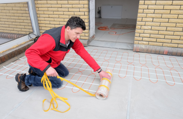 Installation d’un plancher chauffant électrique avant pose de carrelage avec colle adaptée aux variations thermiques.