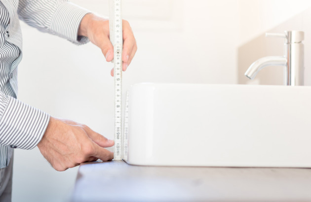Homme qui mesure la hauteur d'une vasque