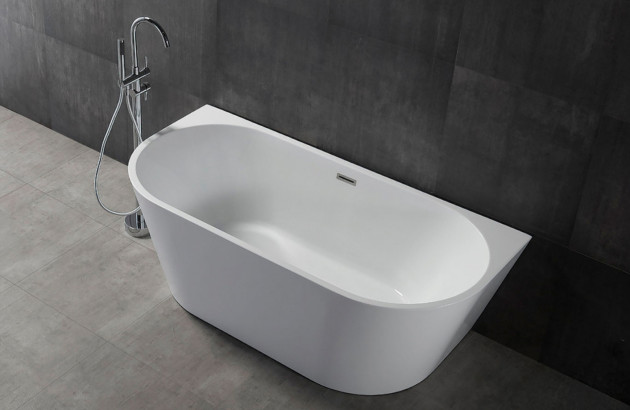 Baignoire ilot posée contre un mur dans une salle de bains sobre