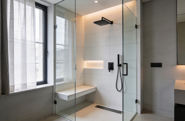 Douche à l’italienne moderne avec banc intégré et robinetterie noire