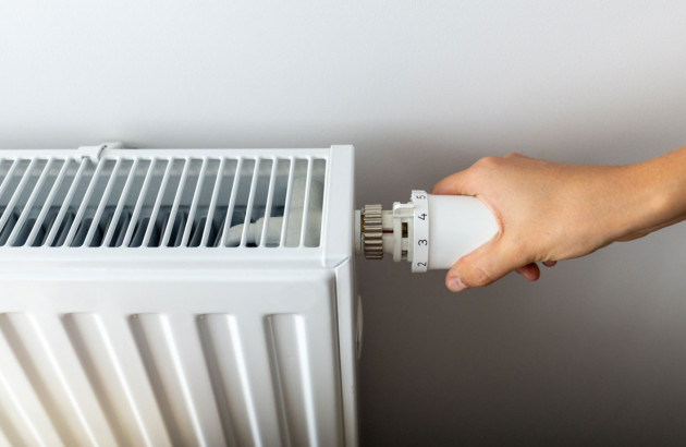 Personne qui utilise le thermostat d'un chauffage