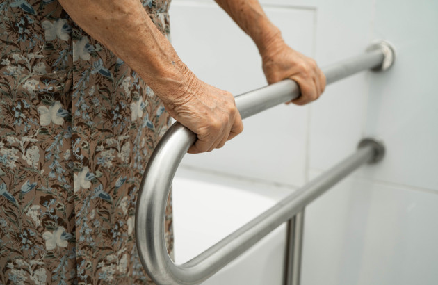 Femme âgée qui tient une barre de douche 