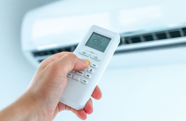 Personne qui utilise une télécommande de climatisation